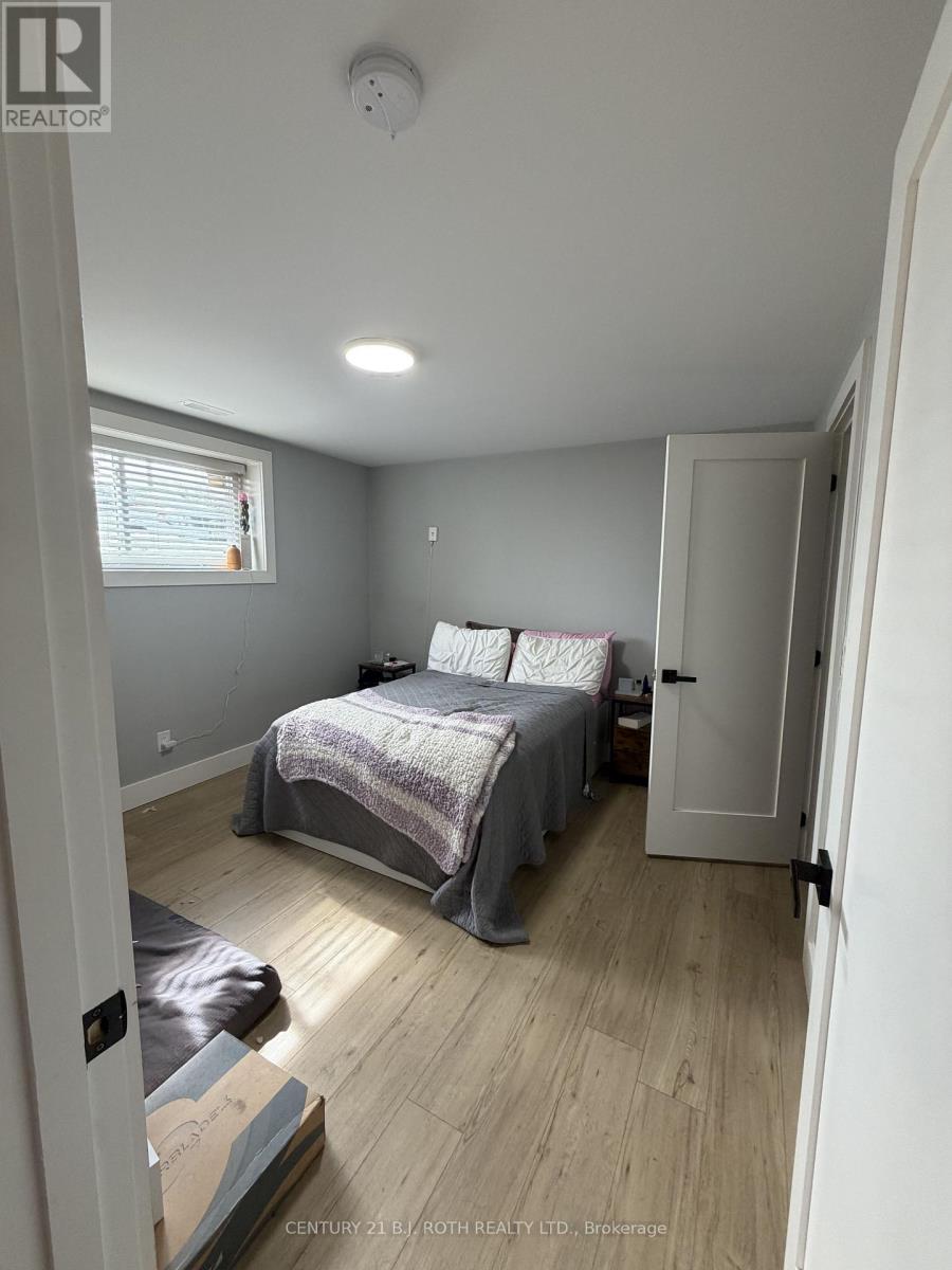 A bedroom with a bed, a window, and a door.