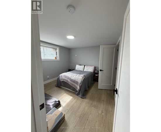 A bedroom with a bed, a window, and a door.