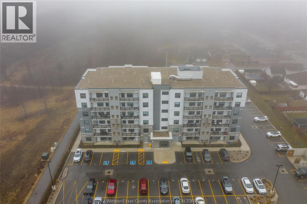 A large apartment complex with a parking lot in front.