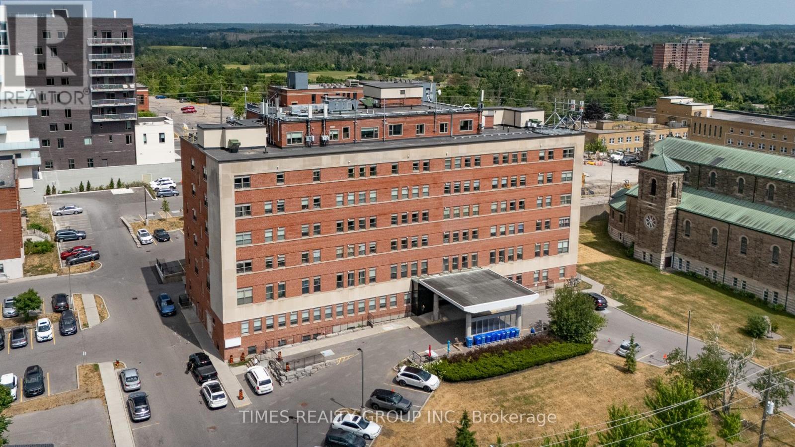 A large red brick building with a parking lot in front of it.