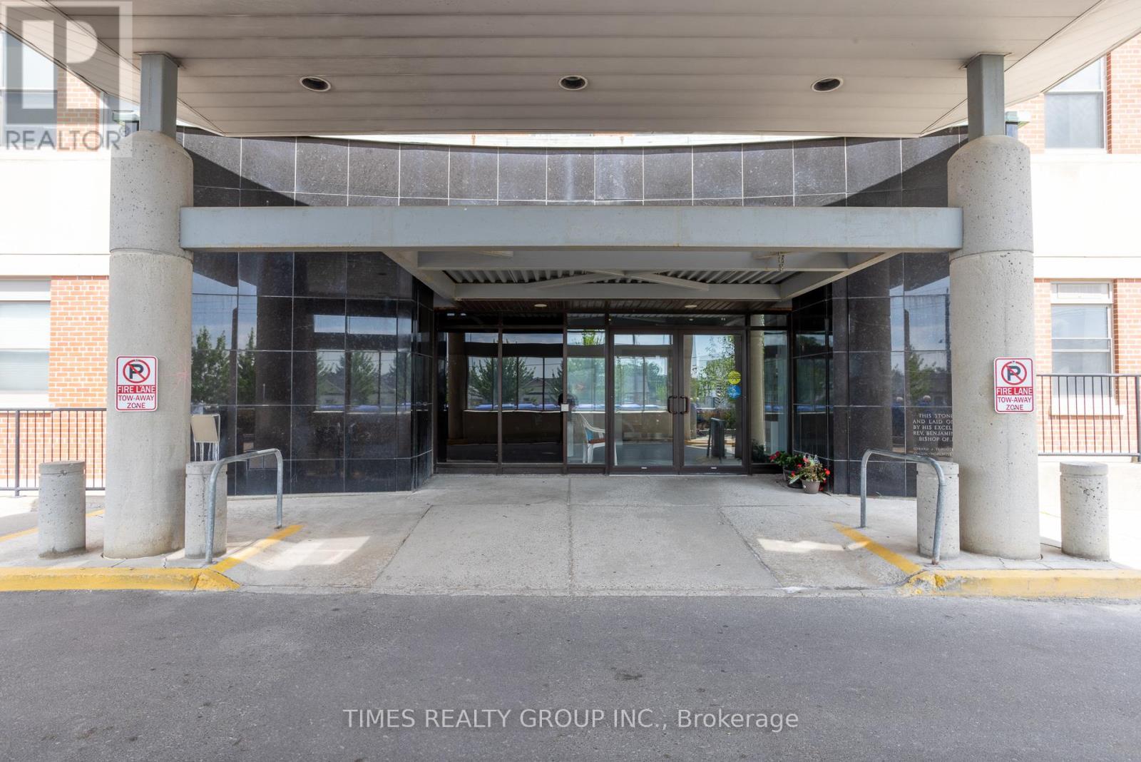 The entrance to a building with a glass door and a no parking sign.