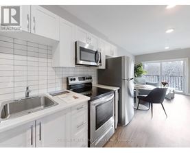 A kitchen with white cabinets and stainless steel appliances.