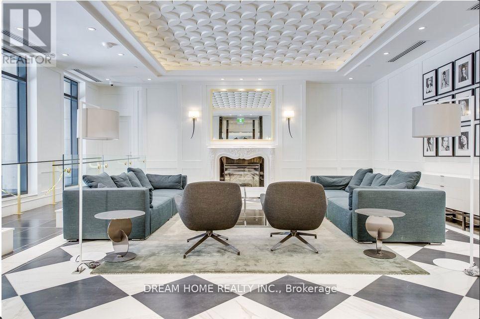A modern living room with a fireplace and two grey armchairs.
