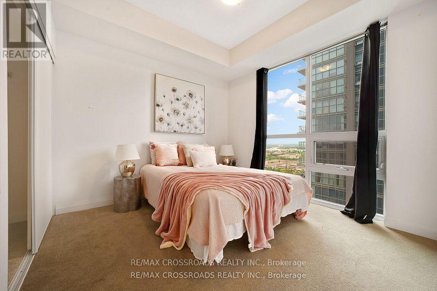 A bedroom with a bed covered in a pink and white comforter.
