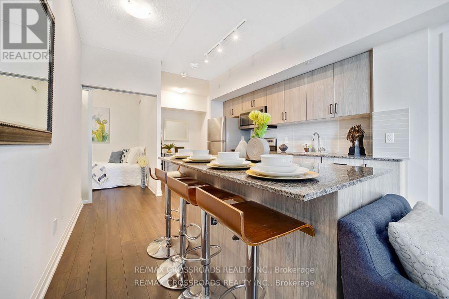 A modern kitchen with a bar stool and a dining table set for two.