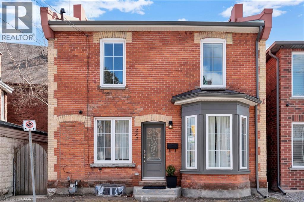 A red brick house with a grey front door and windows.