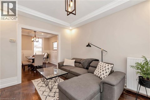 A living room with a grey couch and a glass table.