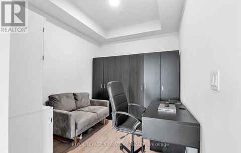 A modern living room with a grey sofa and a black chair.