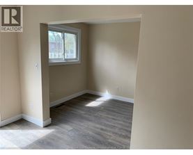 A room with a window and wooden flooring.