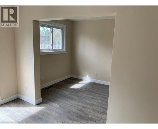 A room with a window and wooden flooring.