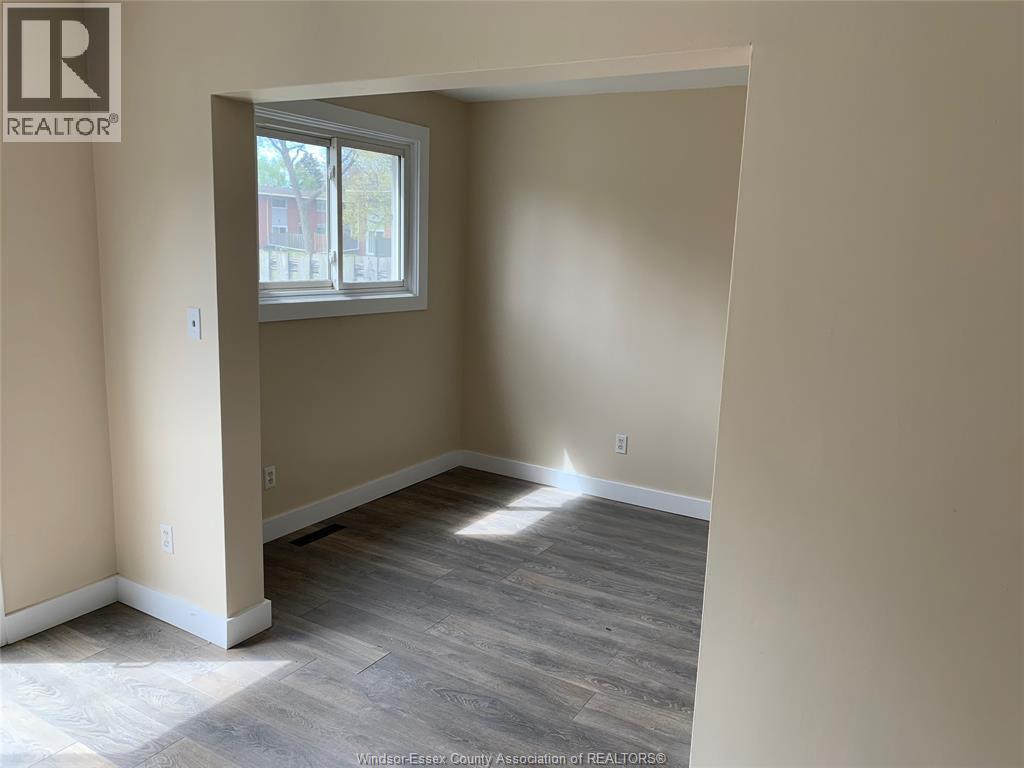 A room with a window and wooden flooring.