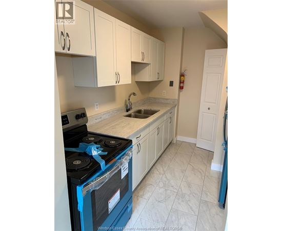 A kitchen with a blue stove top oven and white cabinets.