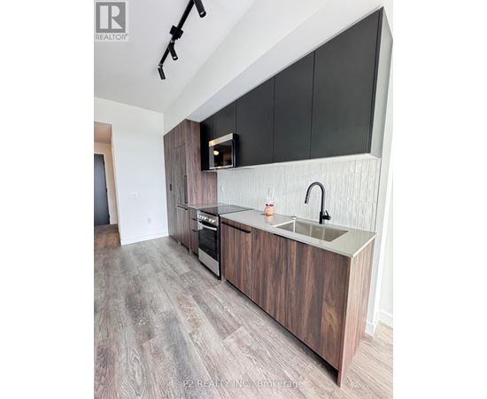 A modern kitchen with dark wood cabinets and a stainless steel sink.