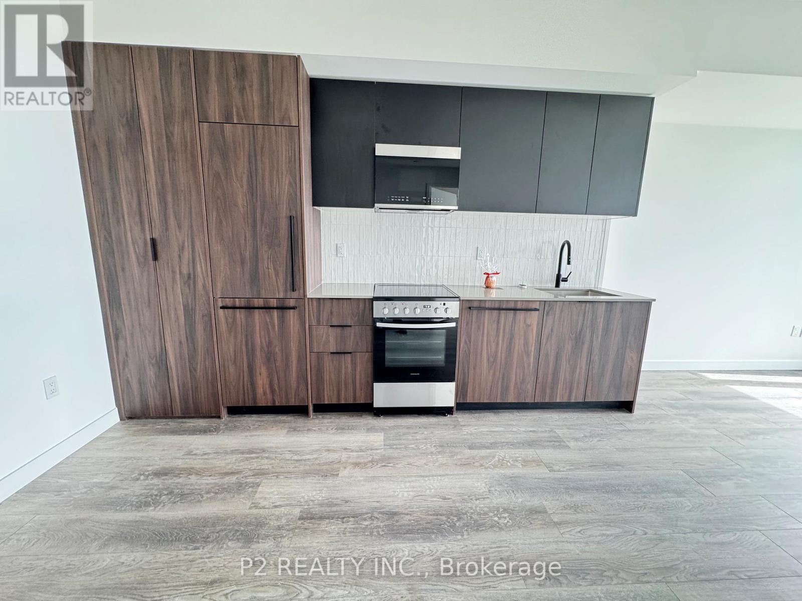 A modern kitchen with dark wood cabinets and a stainless steel oven.
