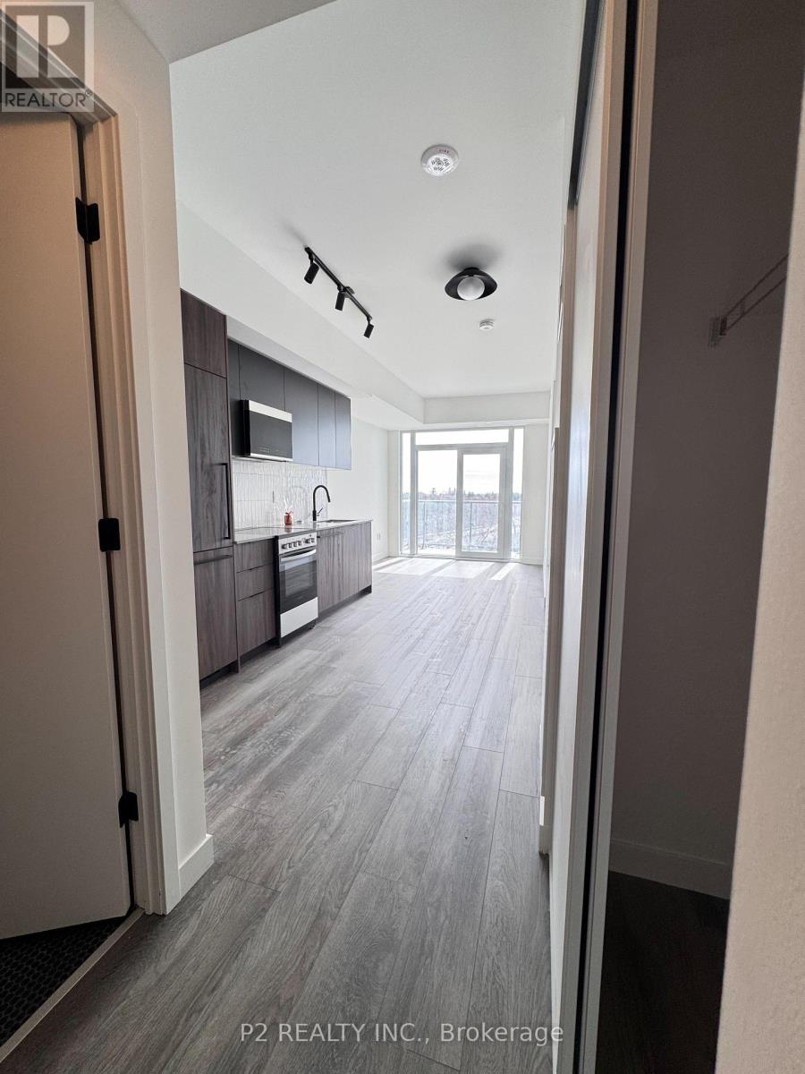 A hallway with a kitchen visible through the door.