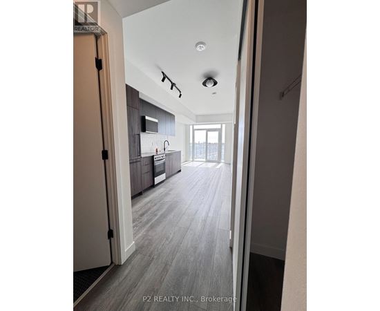 A hallway with a kitchen visible through the door.