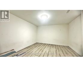A room with wooden flooring and a ceiling light.