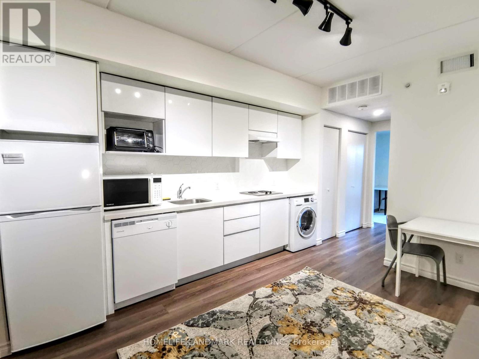 A kitchen with white appliances and cabinets.