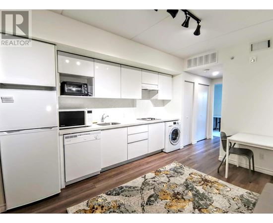 A kitchen with white appliances and cabinets.
