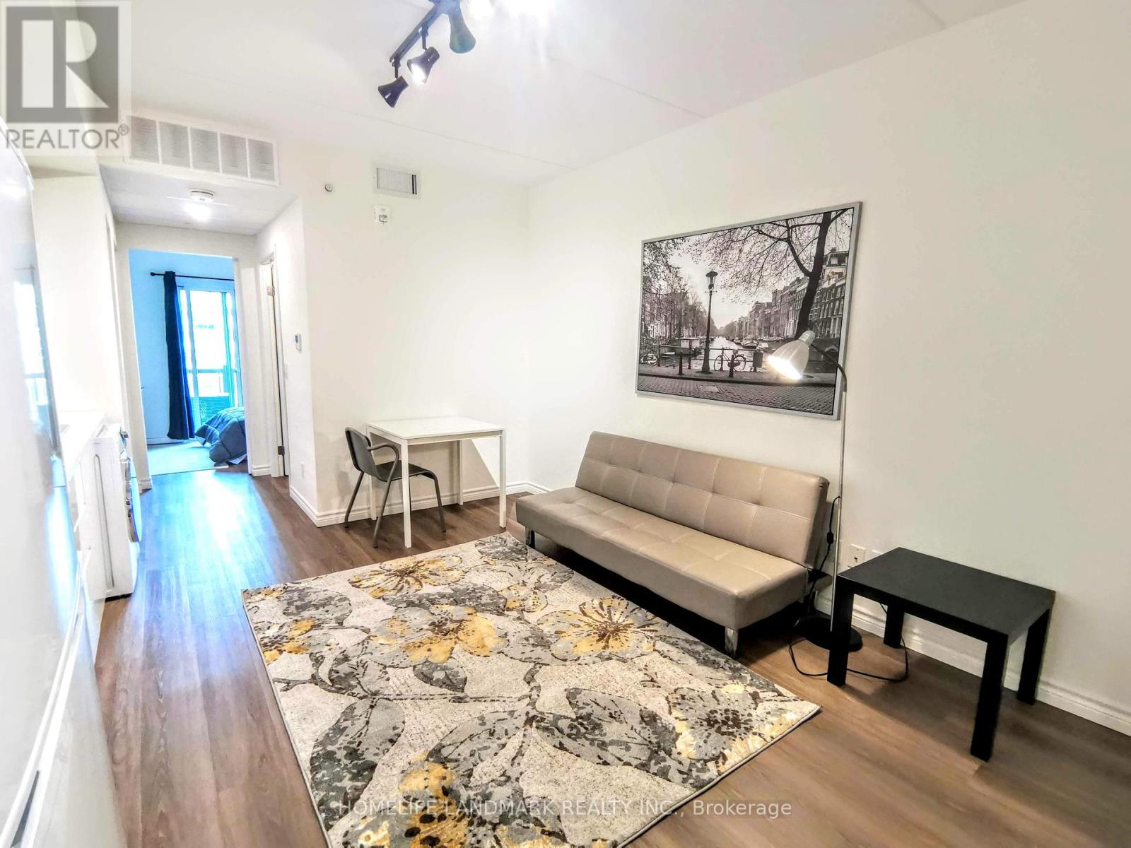 A living room with a couch, chair, and rug.