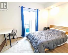 A bedroom with a bed, desk, and chair.