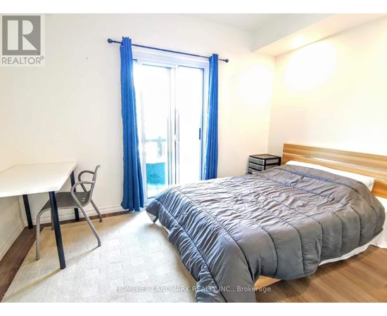 A bedroom with a bed, desk, and chair.
