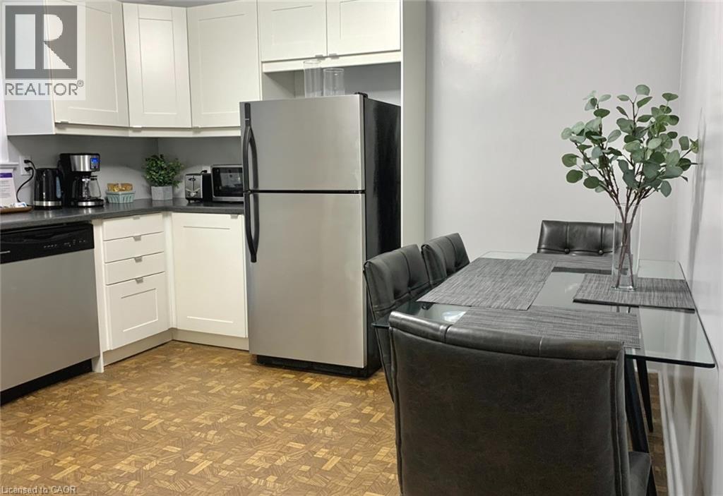 A modern kitchen with a refrigerator, dining table, and chairs.