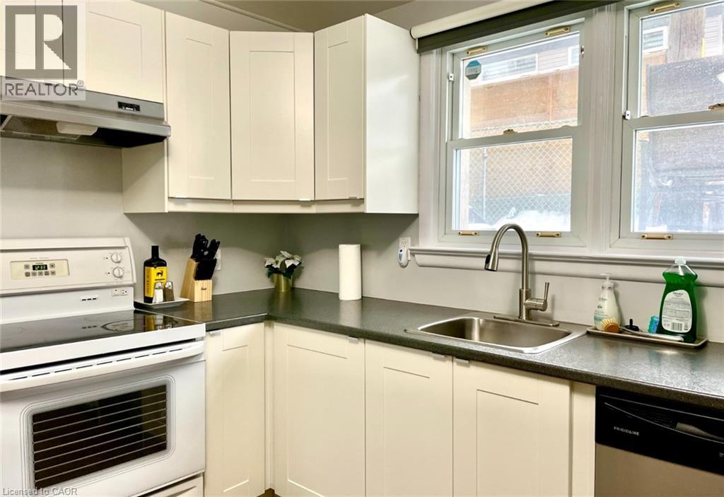 A kitchen with white cabinets and a stainless steel sink.