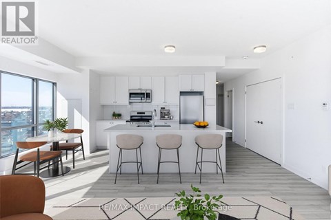 A modern kitchen with white cabinets and a bar area.