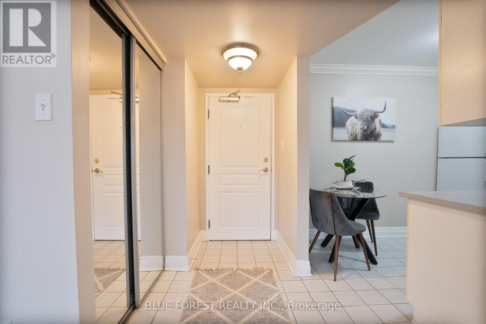 A hallway with a table and chairs in the middle.