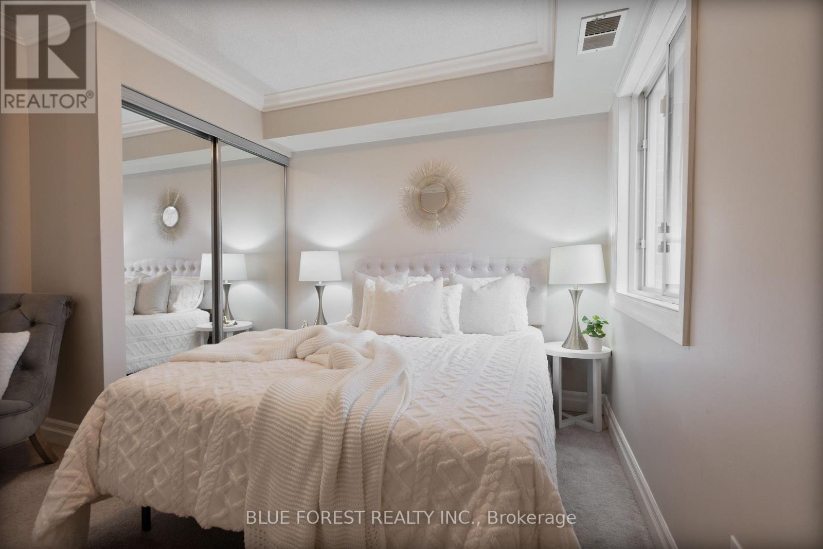 A bedroom with a large bed and a mirror on the wall.