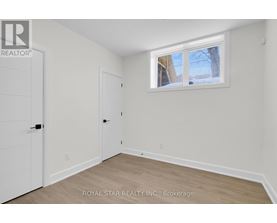 A grey building with a glass door and a snowy sidewalk.