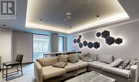 A modern living room with a grey sofa and a black chair.