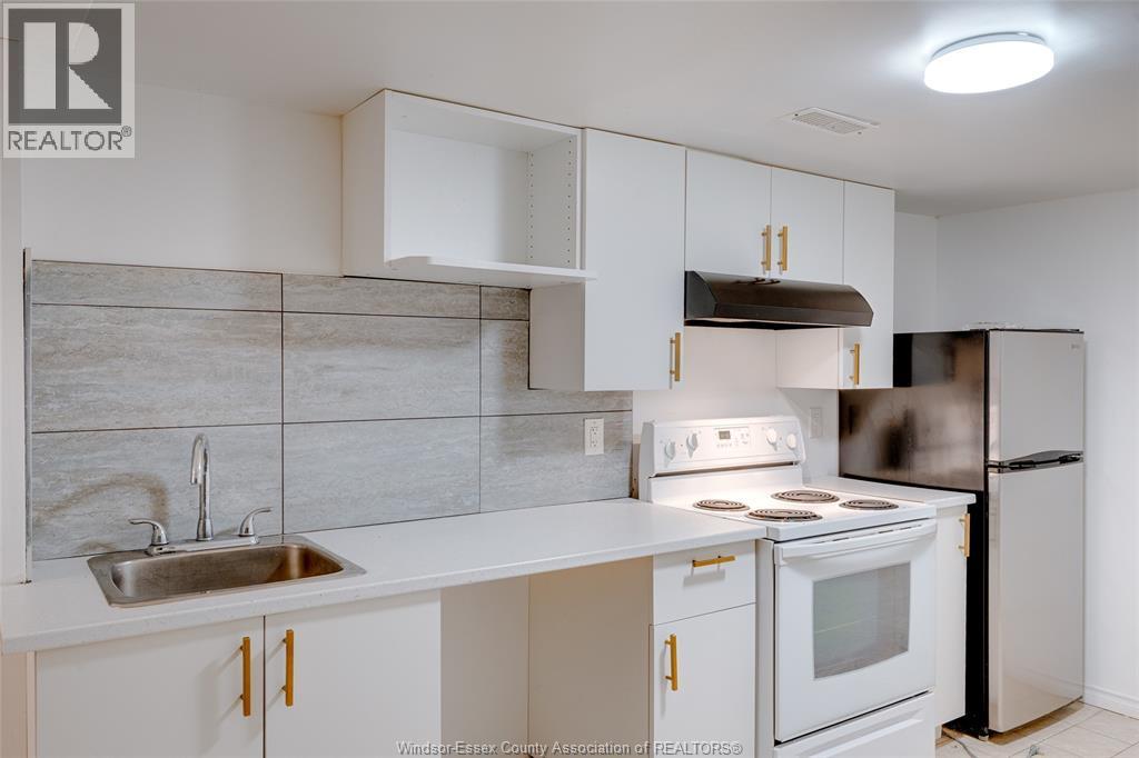 A kitchen with white cabinets and a stainless steel refrigerator.