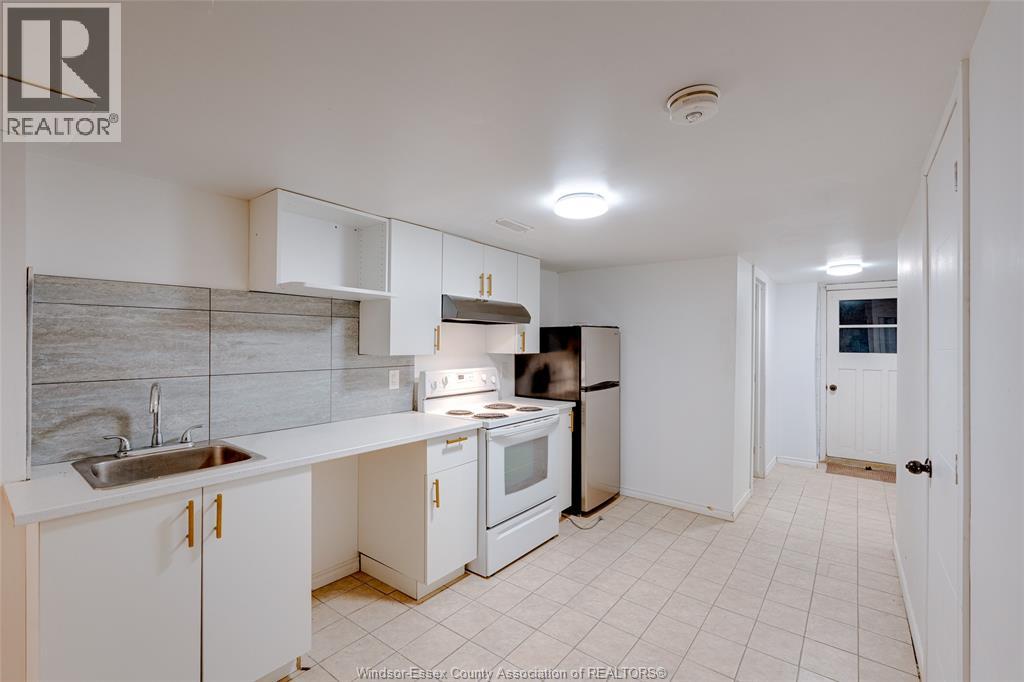 A kitchen with white cabinets and a black stove top oven.