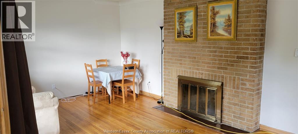 A living room with a fireplace and a dining table.