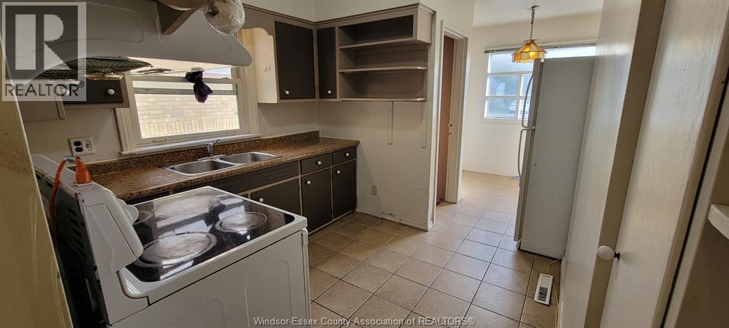A kitchen with a stove top oven and a sink.