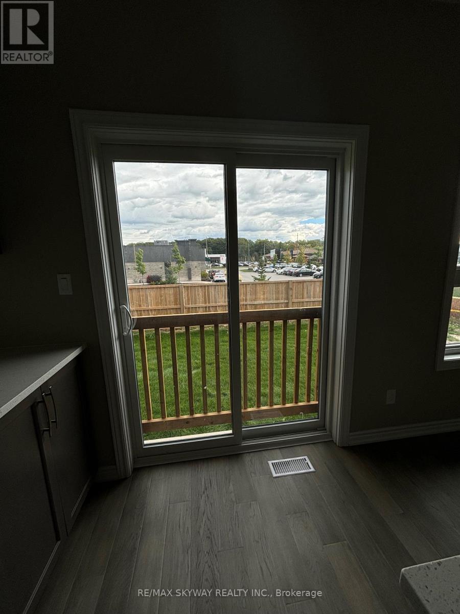 A view from a window looking out to a parking lot and a wooden fence.