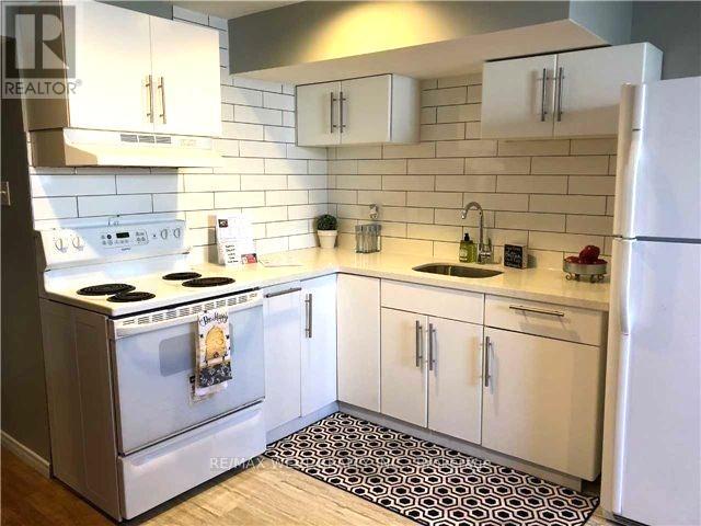 A kitchen with white appliances and cabinets.