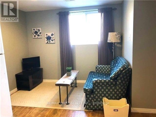 A living room with a blue patterned chair and a black television.