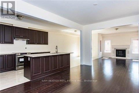 A spacious kitchen with dark wood cabinets and a marble countertop.
