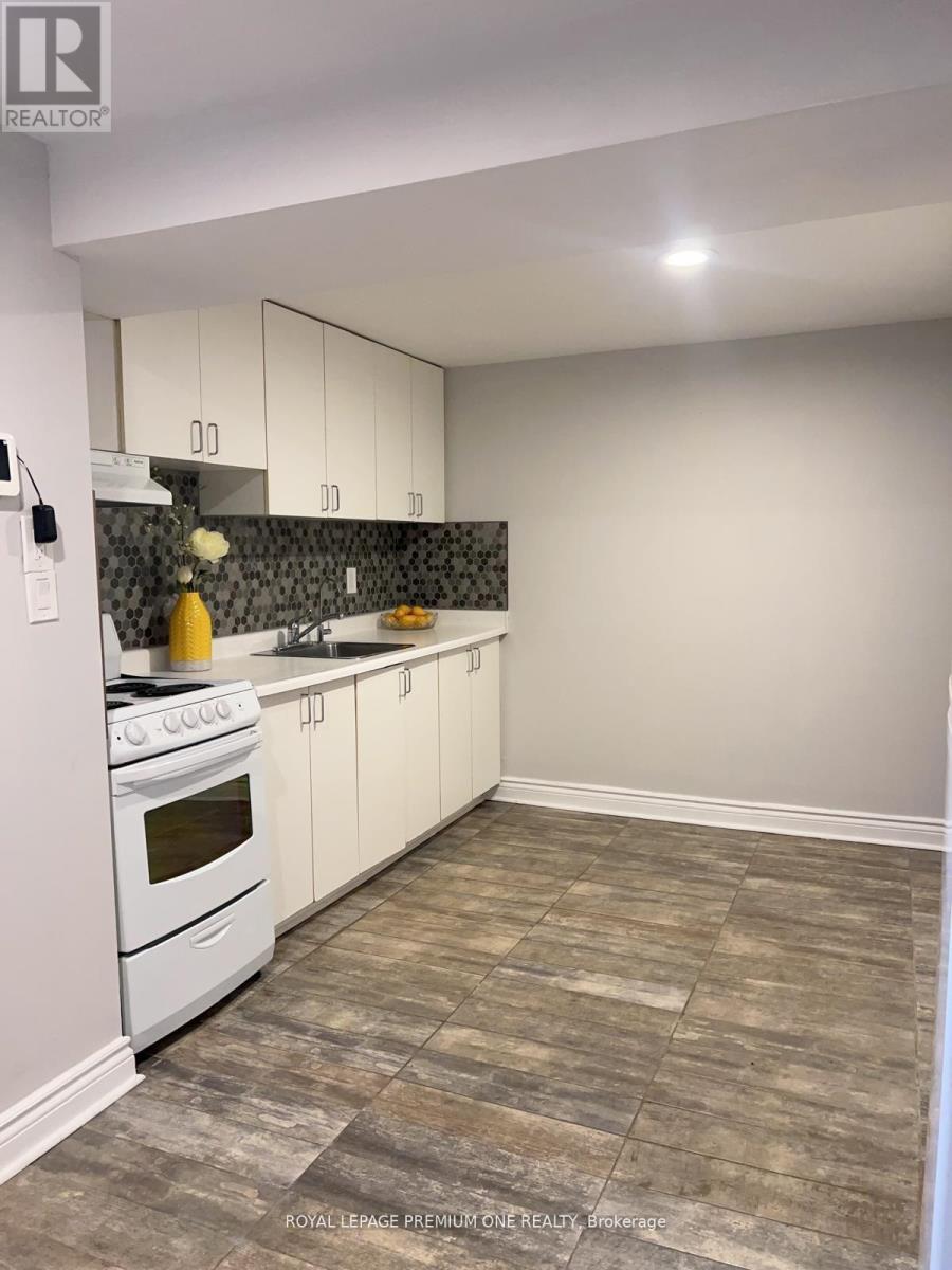 A kitchen with white cabinets and a white stove top oven.