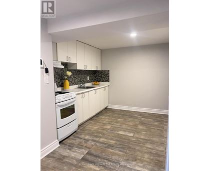 A kitchen with white cabinets and a white stove top oven.