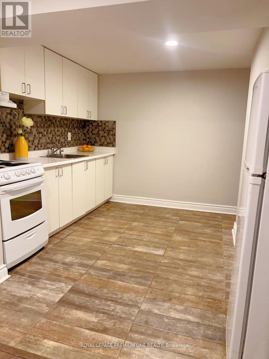 A kitchen with white appliances and a tiled floor.