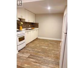 A kitchen with white appliances and a tiled floor.