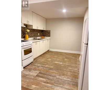 A kitchen with white appliances and a tiled floor.