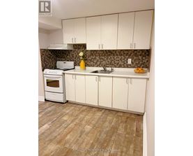 A kitchen with white cabinets and a tiled backsplash.
