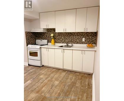 A kitchen with white cabinets and a tiled backsplash.