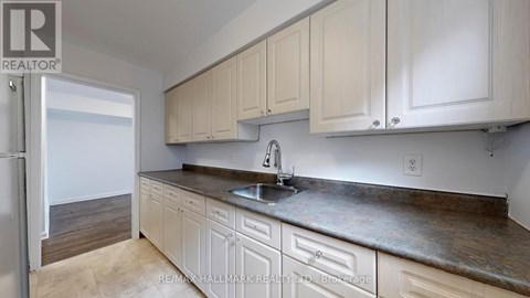 A kitchen with white cabinets and a sink.
