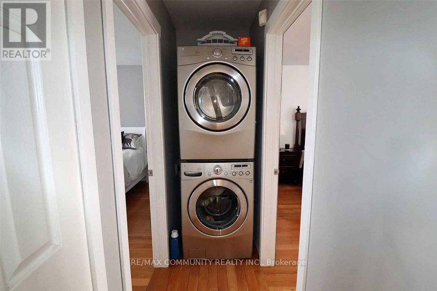 A washing machine is in a small space between two walls.